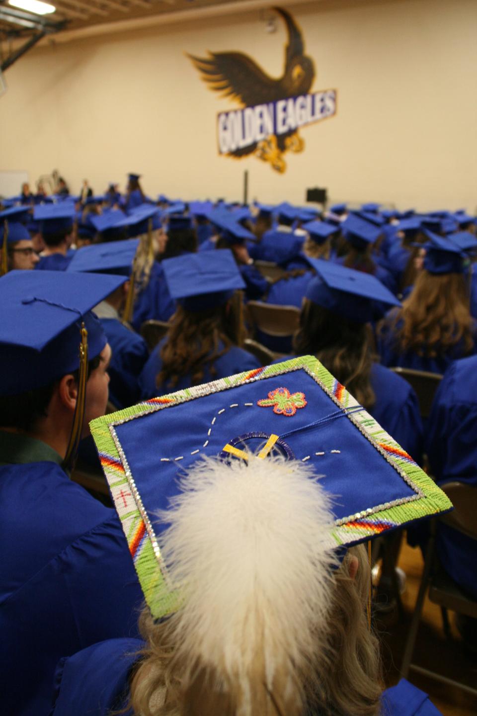 Some students decorated their mortarboards for the graduation ceremony at Central High School Sunday afternoon. Here, members of the Class of 2022 wait in the auxiliary gym before the ceremony.