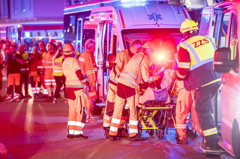 Firefighters work at the scene of a train crash in Pardubice