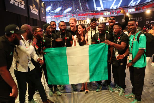 <p>Chris Jackson/Getty</p> Prince Harry and Meghan Markle pose for a photo with members of Team Nigeria at the 2023 Invictus Games