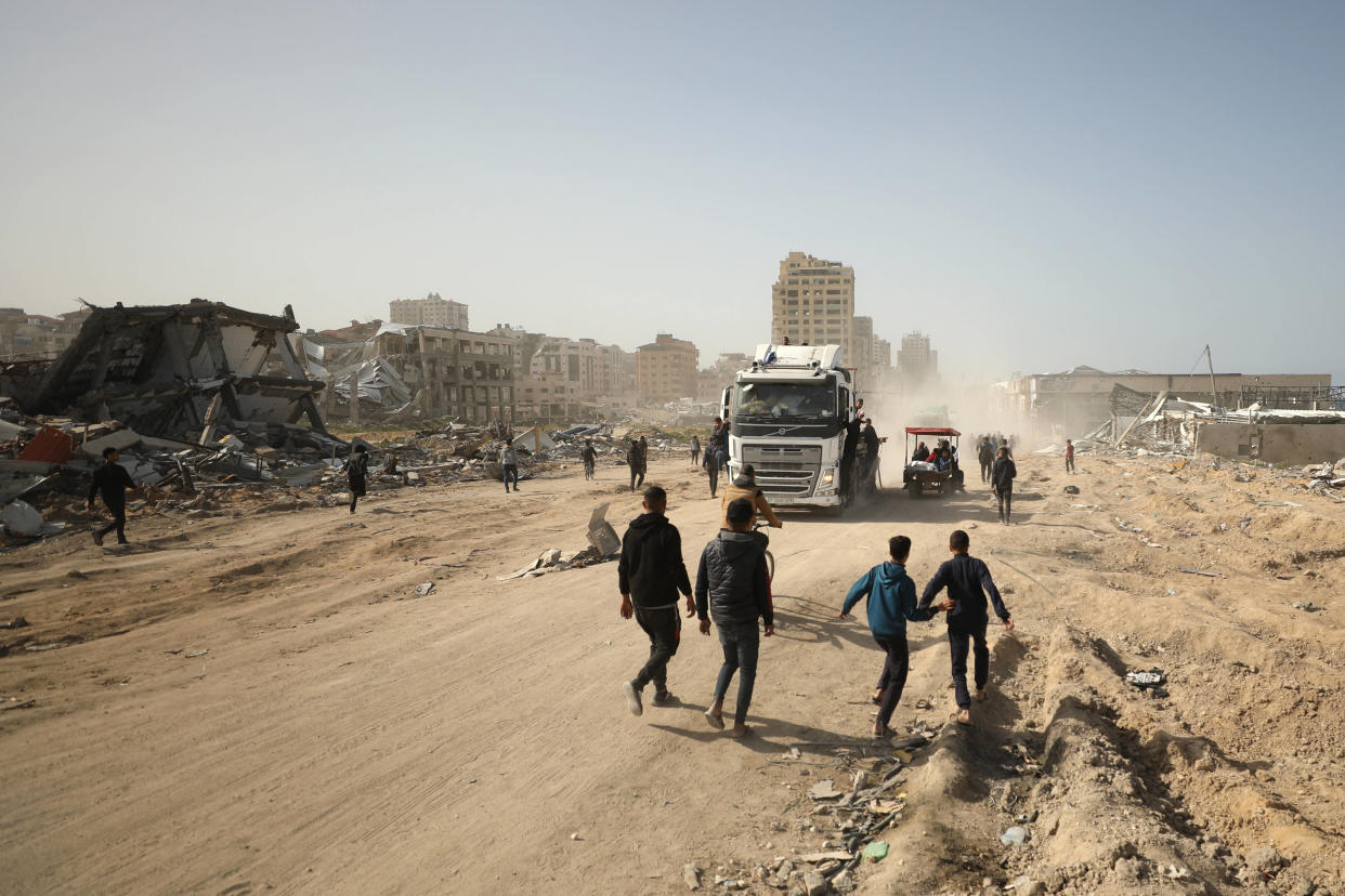 Des Palestiniens courent le long d’une rue alors que l’aide humanitaire arrive dans la ville de Gaza le 6 mars 2024, dans le cadre du conflit actuel entre Israël et le groupe militant du Hamas.