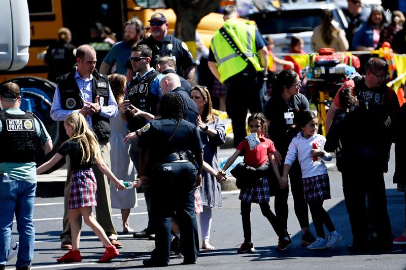 Students from the Covenant School hold hands after getting off a bus following a mass shooting in Nashville