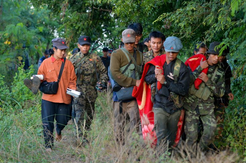 FILE PHOTO: People's Liberation Army PLA members, carry an injured person as they fight the Myanmar junta army near Sagaing Region in Myanmar