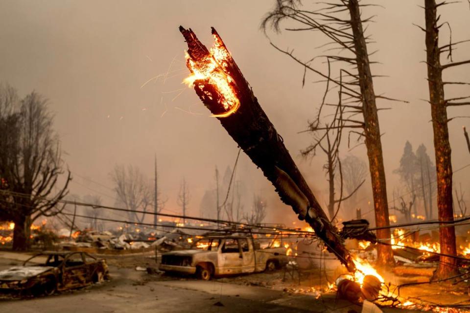 A utility pole burns as the Dixie Fire tears through the Greenville community of Plumas County, Calif., on Wednesday, Aug. 4, 2021. The fire leveled multiple historic buildings and dozens of homes in central Greenville. (AP Photo/Noah Berger)