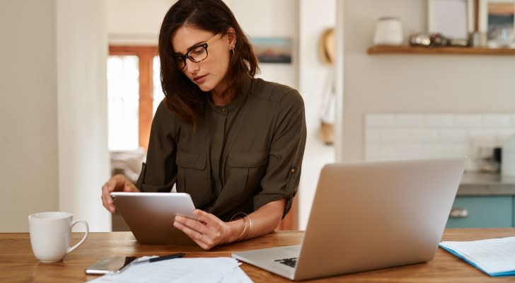 A woman comparing the tax requirements for traditional and Roth IRAs. 