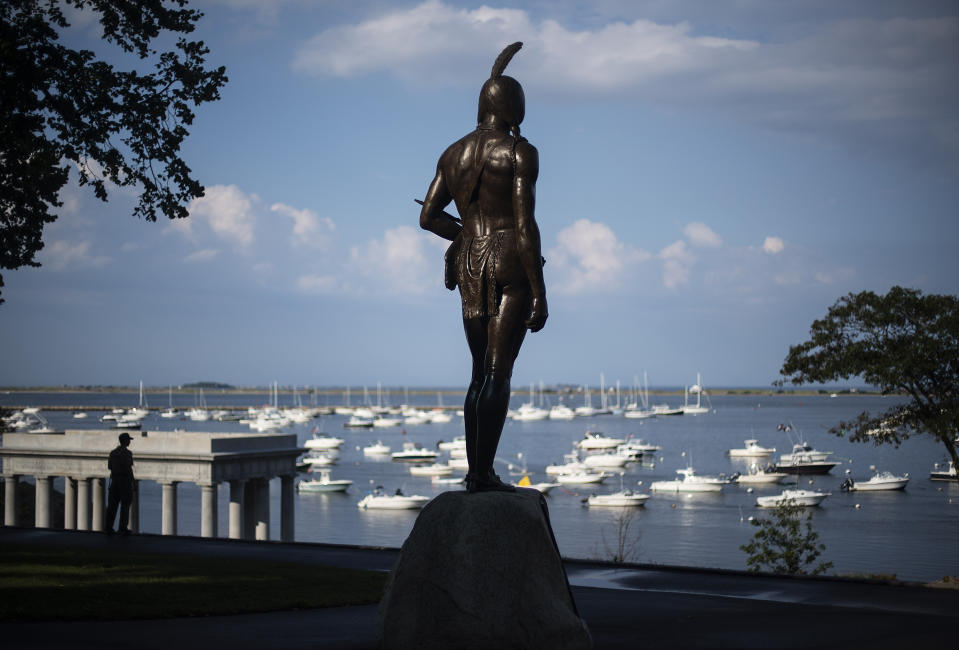 A statue of the Native Sachem (leader) Massasoit looks out over the traditional point of arrival of the Pilgrims on the Mayflower in 1620, in Plymouth, Mass., Wednesday, Aug. 12, 2020. In the years preceding the Pilgrims' arrival, the Native inhabitants of southern New England had been ravaged by what some scientists refer to as a "virgin soil" epidemic. The unidentified disease, perhaps introduced by European fishermen who plied the waters from Maine to Narragansett Bay, burned through village after village, killing up to 90 percent of some tribes. (AP Photo/David Goldman)