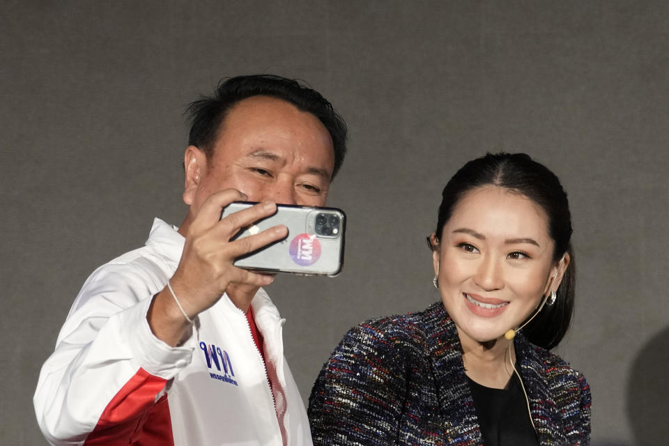 A supporter takes a selfie with the daughter of Thailand's former Prime Minister Thaksin Shinawatra, Paetongtarn Shinawatra during a Pheu Thai party general assembly meeting in Bangkok, Thailand, Tuesday, Dec. 6, 2022. Shinawatra promised a new era of social equality Tuesday, saying if her party is elected to power in next year's election it will bring an end to poverty in the Southeast Asian nation. (AP Photo/Sakchai Lalit)