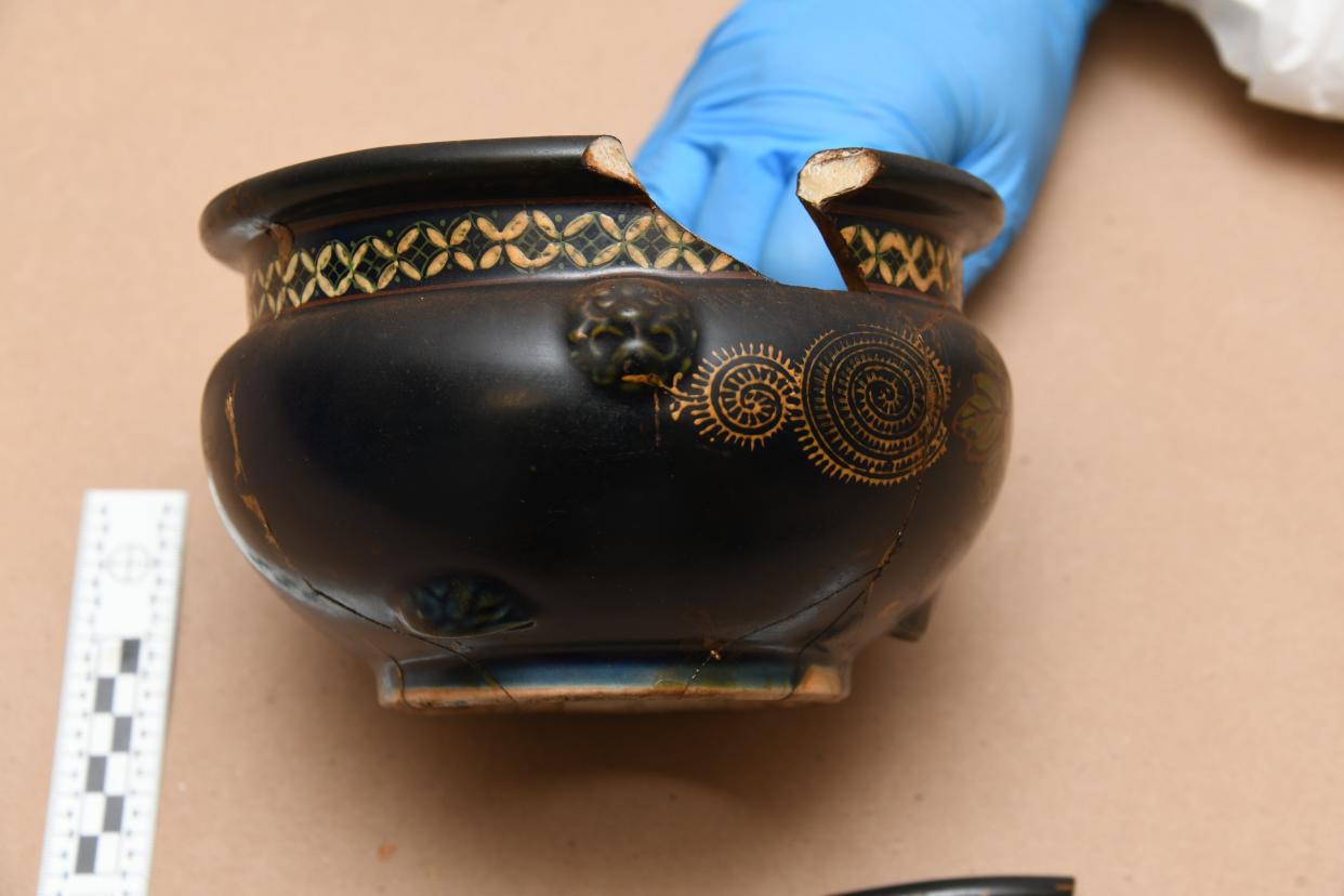 A gloved hand holds one of a few bowls that was among 22 plundered Japanese artifacts found in a deceased WWII veteran's Massachusetts home. The FBI transported the artifacts from Massachusetts to Smithsonian Institution's National Museum of Asian Art in Washington, D.C. before they were handed over in Okinawa last week.