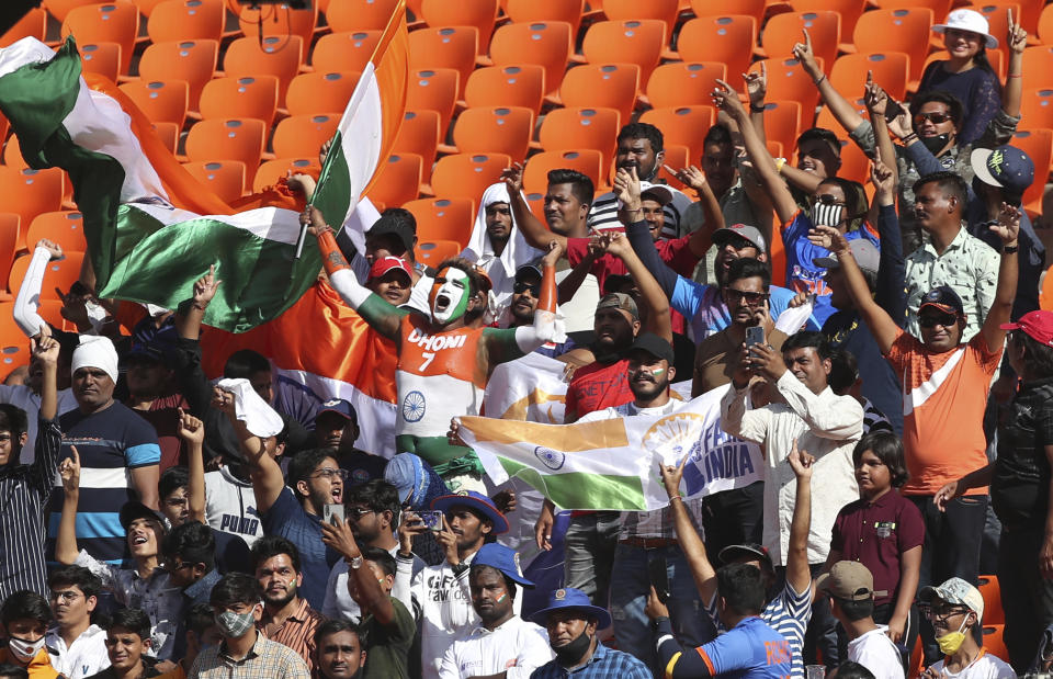 Indian fans celebrate at the end of England's first innings during the first day of fourth cricket test match between India and England at Narendra Modi Stadium in Ahmedabad, India, Thursday, March 4, 2021. (AP Photo/Aijaz Rahi)