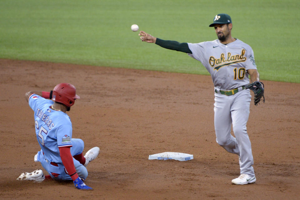 Oakland Athletics shortstop Marcus Semien (10) makes the throw to first on a double play over Texas Rangers Leody Taveras (65) in the third inning during a baseball game in Arlington, Tex, Sunday, Sept. 13, 2020. (AP Photo/Matt Strasen)