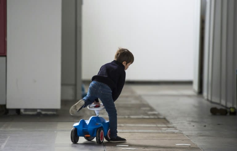 A child in a temporary shelter for refugees in one of the halls of Berlin's trade fair ground on October 7, 2015