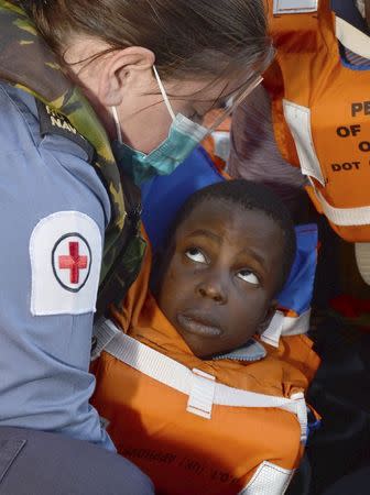 Royal Navy medical assistant Morwenna Nichols tends to four year-old Milako Izic after his rescue by HMS Bulwark from the Mediterranean between Italy and North Africa, May 13, 2015. REUTERS/Crown Copyright/Carl Osmond/Handout via Reuters