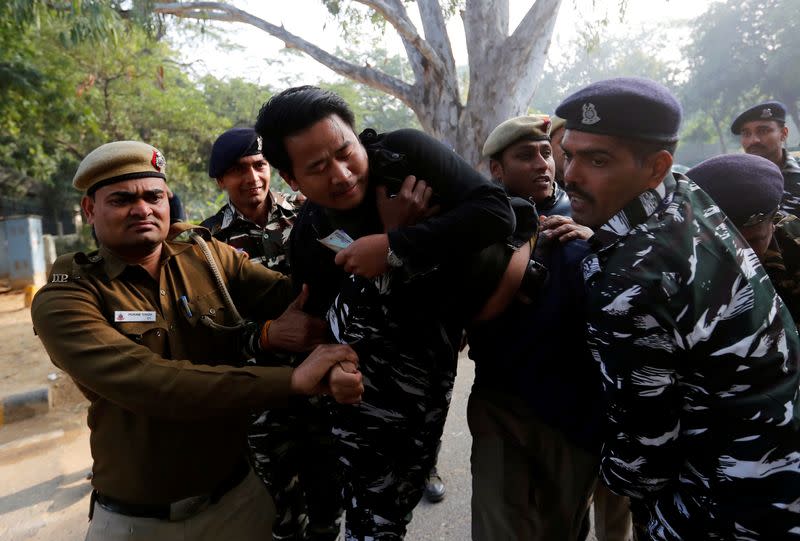 A demonstrator is detained by police outside the Assam bhawan (building) during a protest against a new citizenship law in New Delhi