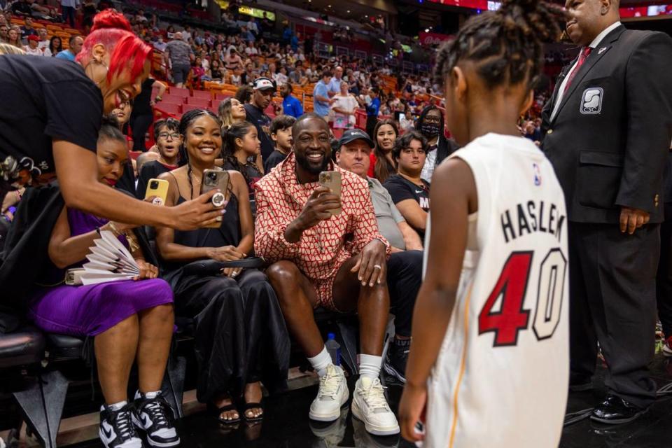 Dwyane Wade, futuro miembro del Salón de la Fama de los Miami Heat, y su esposa, Gabrielle Union, toman fotos de su hija Kaavia James Union-Wade mientras se pone una camiseta de Udonis Haslem antes del primer cuarto de un partido de la NBA contra los Orlando Magic en el Kaseya Center en el downtown de Miami, Florida, el domingo 9 de abril de 2023.