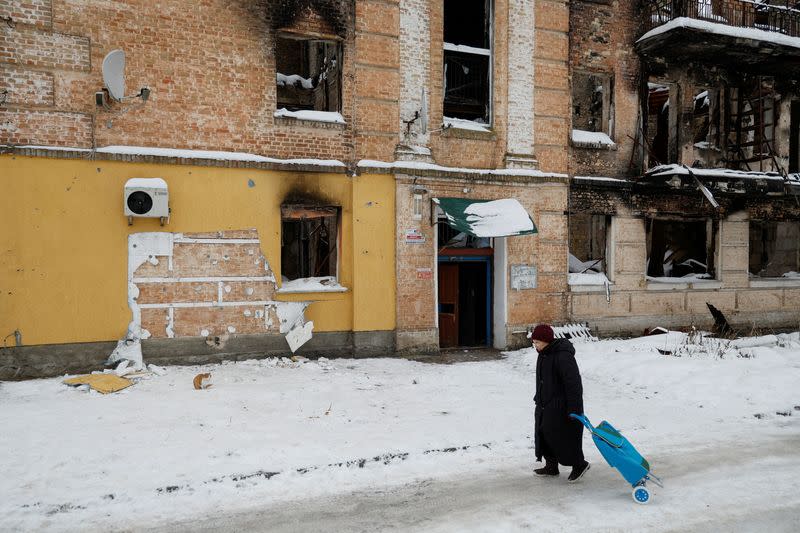 FILE PHOTO: Local woman walks next to a wall of a residential building from which a group of people tried to steal the work of street artist Banksy, in the town of Hostomel