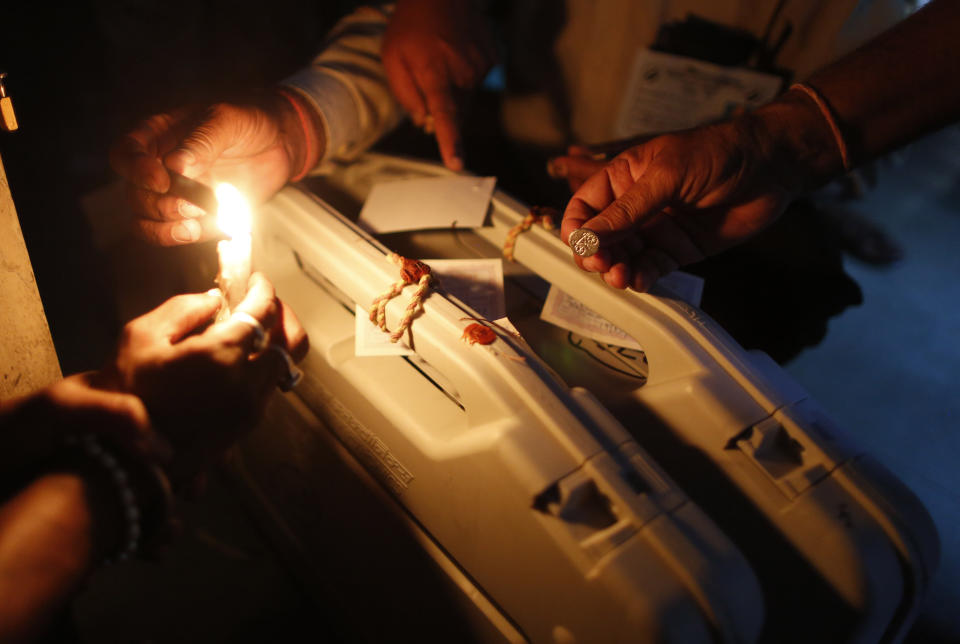 Election officers seal an electronic voting machine at the end of polling in Varanasi, India, Sunday, May 19, 2019. Indians voted in the seventh and final phase of national elections, wrapping up a 6-week-long long, grueling campaign season with Prime Minister Narendra Modi's Hindu nationalist party seeking reelection for another five years. Counting of votes is scheduled for May 23. (AP Photo/Rajesh Kumar Singh)