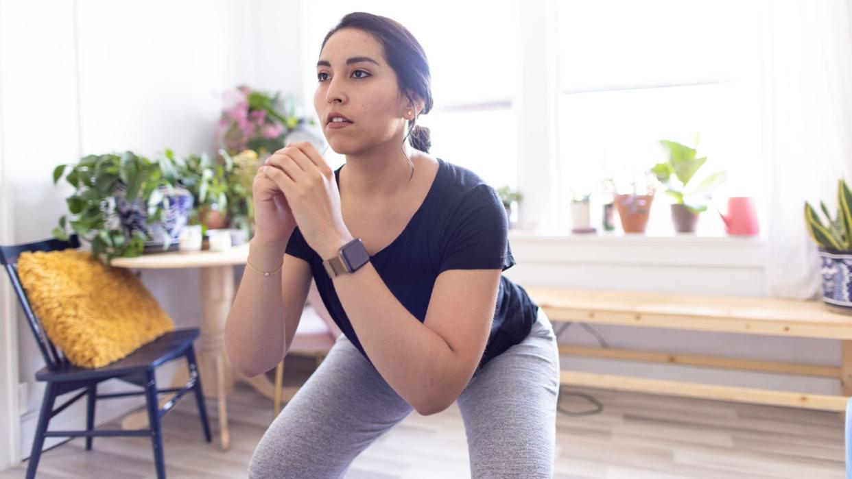  Woman does bodyweight squat. 