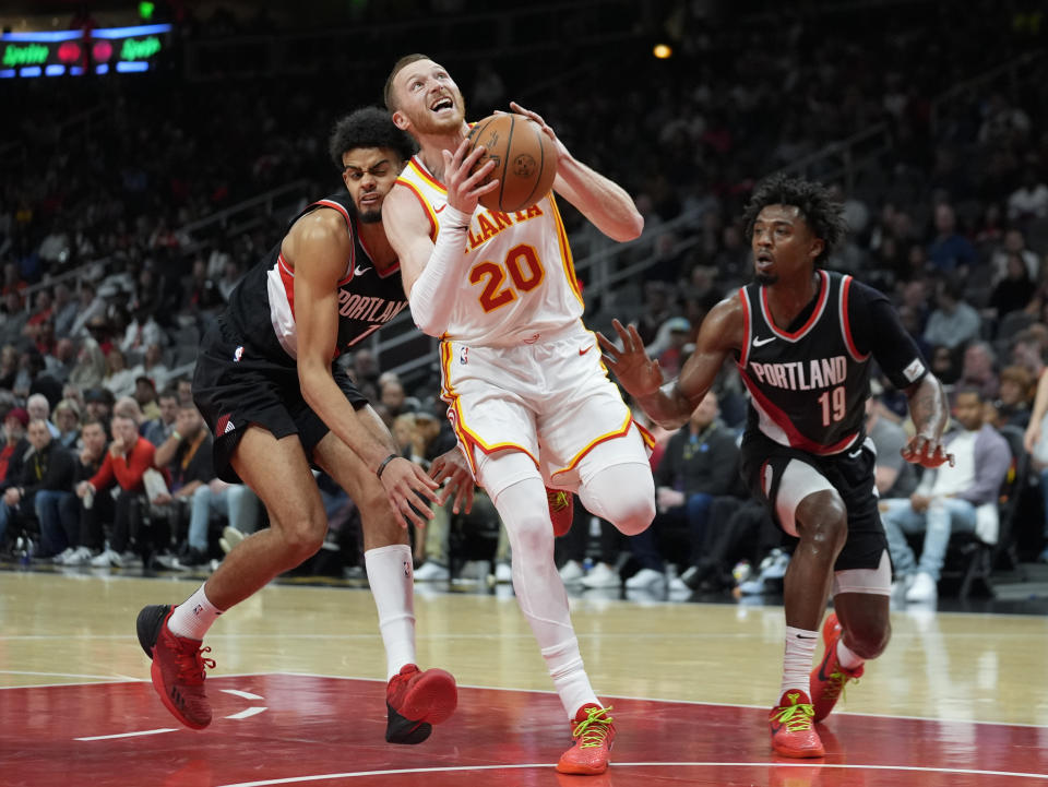 Atlanta Hawks guard Dylan Windler (20) drives between Portland Trail Blazers guard Shaedon Sharpe (17) and Ashton Hagans during the first half of an NBA basketball game Wednesday, March 27, 2024, in Atlanta. (AP Photo/John Bazemore)