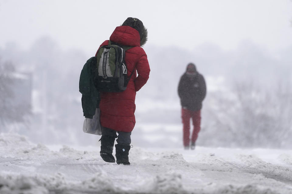 La gente camina sobre una calle nevada durante la tormenta invernal que azota a la región en Kansas City, Misuri, EE.UU. el martes 9 de enero del 2024. (AP Foto/Charlie Riedel)