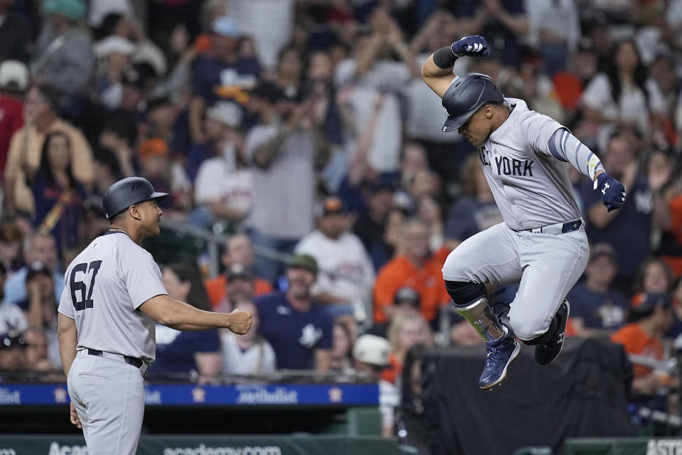 New York Yankees' Juan Soto, right, celebrates with third base coach Luis Rojas after hitting a solo home run against the Houston Astros during the seventh inning of a baseball game Saturday, March 30, 2024, in Houston. (AP Photo/Kevin M. Cox)
