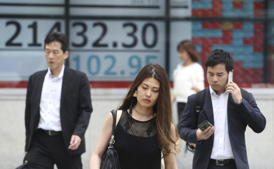 People walk by an electronic stock board of a securities firm in Tokyo, Wednesday, July 17, 2019. Asian stocks were mixed Wednesday as Wall Street ended a five-day winning streak after the first big round of corporate earnings reports. (AP Photo/Koji Sasahara)