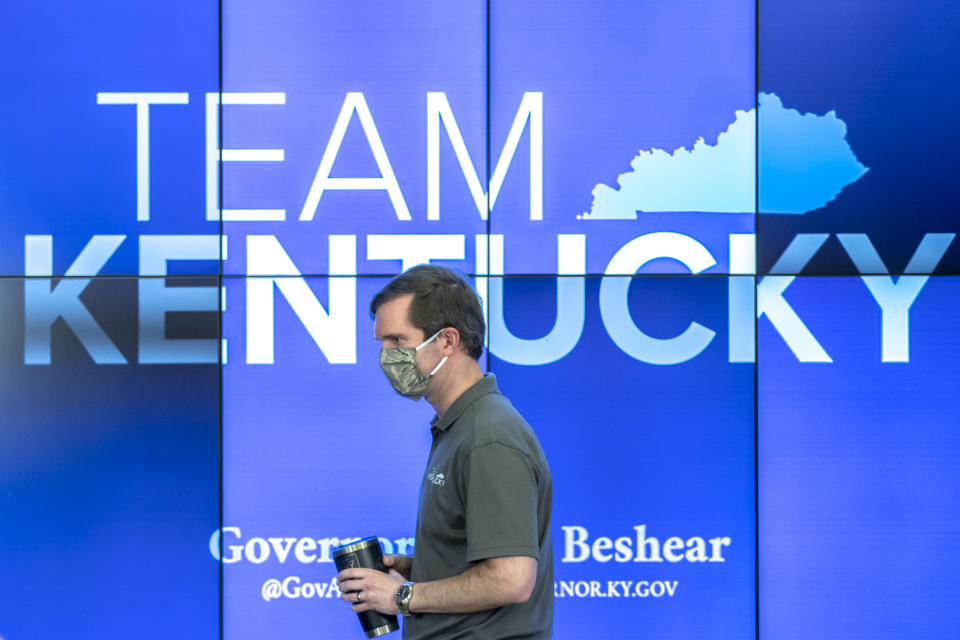 Kentucky Gov. Andy Beshear walks to the podium during a news conference at the state's Emergency Operations Center at the Boone National Guard Center in Frankfort, Ky., to provide an update on the coronavirus situation, Sunday, May 3, 2020. (Ryan C. Hermens/Lexington Herald-Leader via AP)