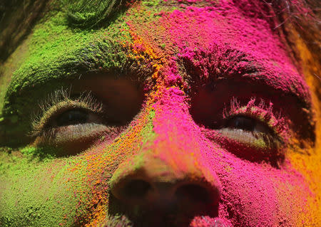 A man daubed in colours looks on during Holi celebrations in Mumbai, India, March 21, 2019. REUTERS/Francis Mascarenhas