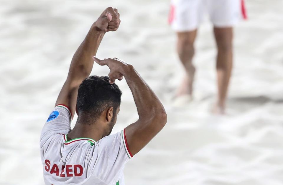 Saeed Piramoun of Iran celebrates after scoring a goal in the Emirates Intercontinental Beach Soccer Cup 2022 final match between Brazil and Iran in Dubai, by pretending to cut his hair in sympathy with protesters (EPA)