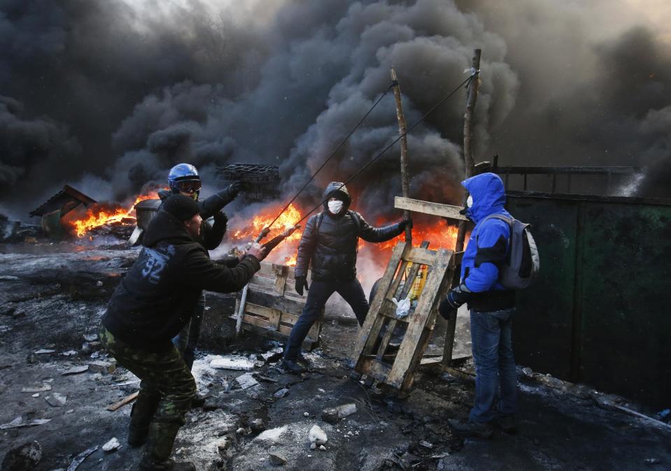 FILE In this file photo taken on Thursday, Jan. 23, 2014, Protesters use a large slingshot to hurl rocks at police in central Kiev, Ukraine. Protesters in Kiev built the catapult to pelt firebombs at police at a longer distance and bigger damage. Thick black smoke from burning tires engulfed parts of downtown Kiev as an ultimatum issued by the opposition to the president to call early election or face street rage was set to expire with no sign of a compromise on Thursday. (AP Photo/Sergei Grits, file)