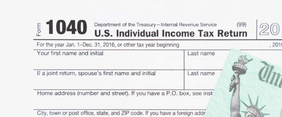 A US Federal tax 1040  income tax form with money and refund check