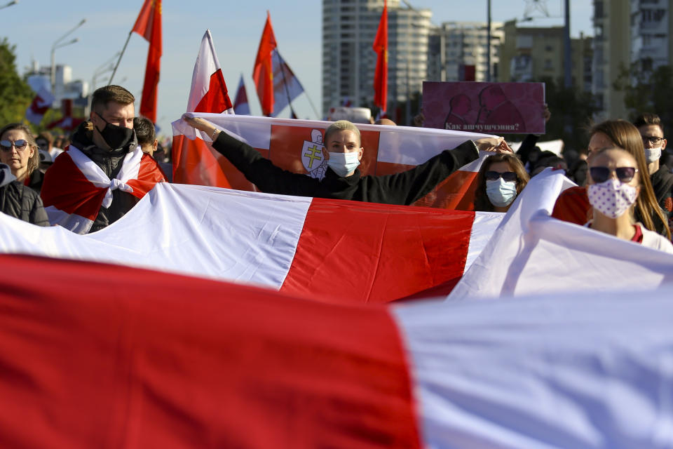 Protesters carry a huge old Belarusian national flag during an opposition rally to protest the official presidential election results in Minsk, Belarus, Sunday, Sept. 20, 2020. Protests calling for the authoritarian president's resignation broke out after an Aug. 9 election that officials say gave him a sixth term in office and that opponents say was rigged. (AP Photo/TUT.by)