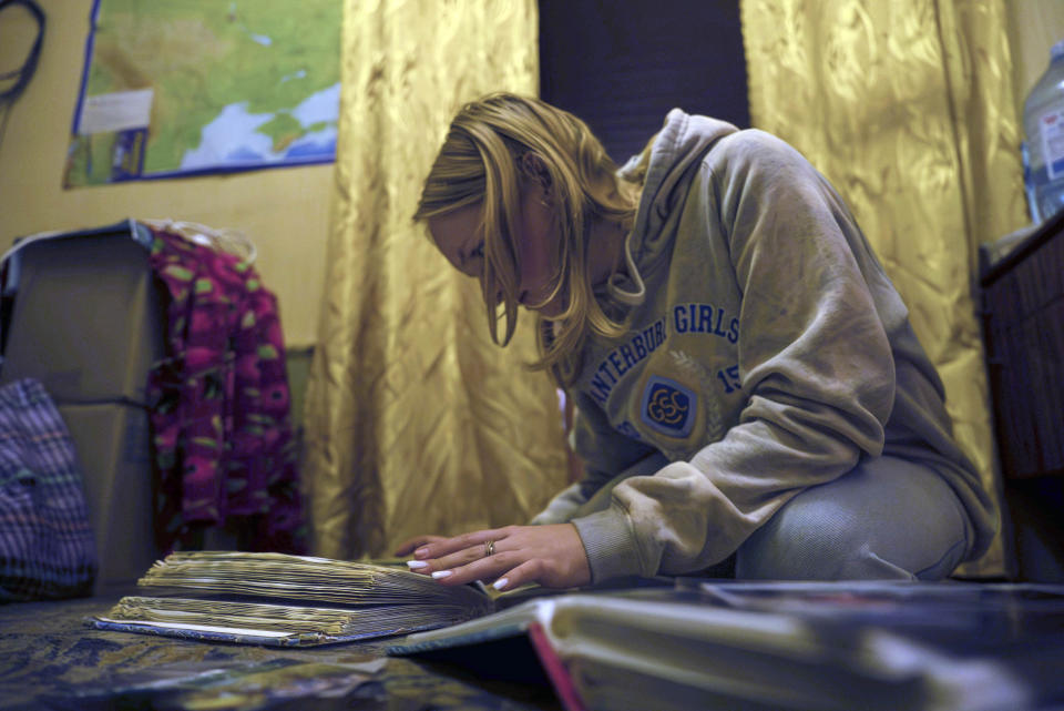 15-year-old Ksiusha Mukhovata shows pictures of her family in the village of Hroza near Kharkiv, Ukraine, Friday, Oct. 6, 2023. Her parents were killed as the Russian rocket hit a village store and cafe in one of the deadliest attacks in recent months, killing at least 51 civilians. (AP Photo/Alex Babenko)