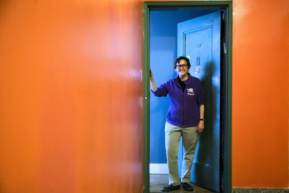 Rabbi Sharon Kleinbaum poses for a photograph at the door to her apartment in New York, Monday, April 6, 2020. Kleinbaum was installed in 1992 as rabbi of Congregation Beit Simchat Torah in Manhattan. It's considered the largest LGBT synagogue in the nation, and AIDS was killing thousands of gay New Yorkers each year when she took the job. That experience has given her strength as New York now faces the coronavirus outbreak. (AP Photo/Matt Rourke)