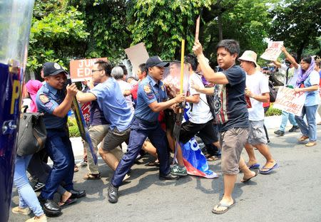 Anti-riot policemen use their shields to push back protesters denouncing the visit of U.S. Secretary of State John Kerry and the Supreme Court's decision to uphold, with finality, the constitutionality of the Enhanced Defense Cooperation Agreement (EDCA) during a protest outside the U.S. embassy in metro Manila, Philippines July 27, 2016. REUTERS/Romeo Ranoco