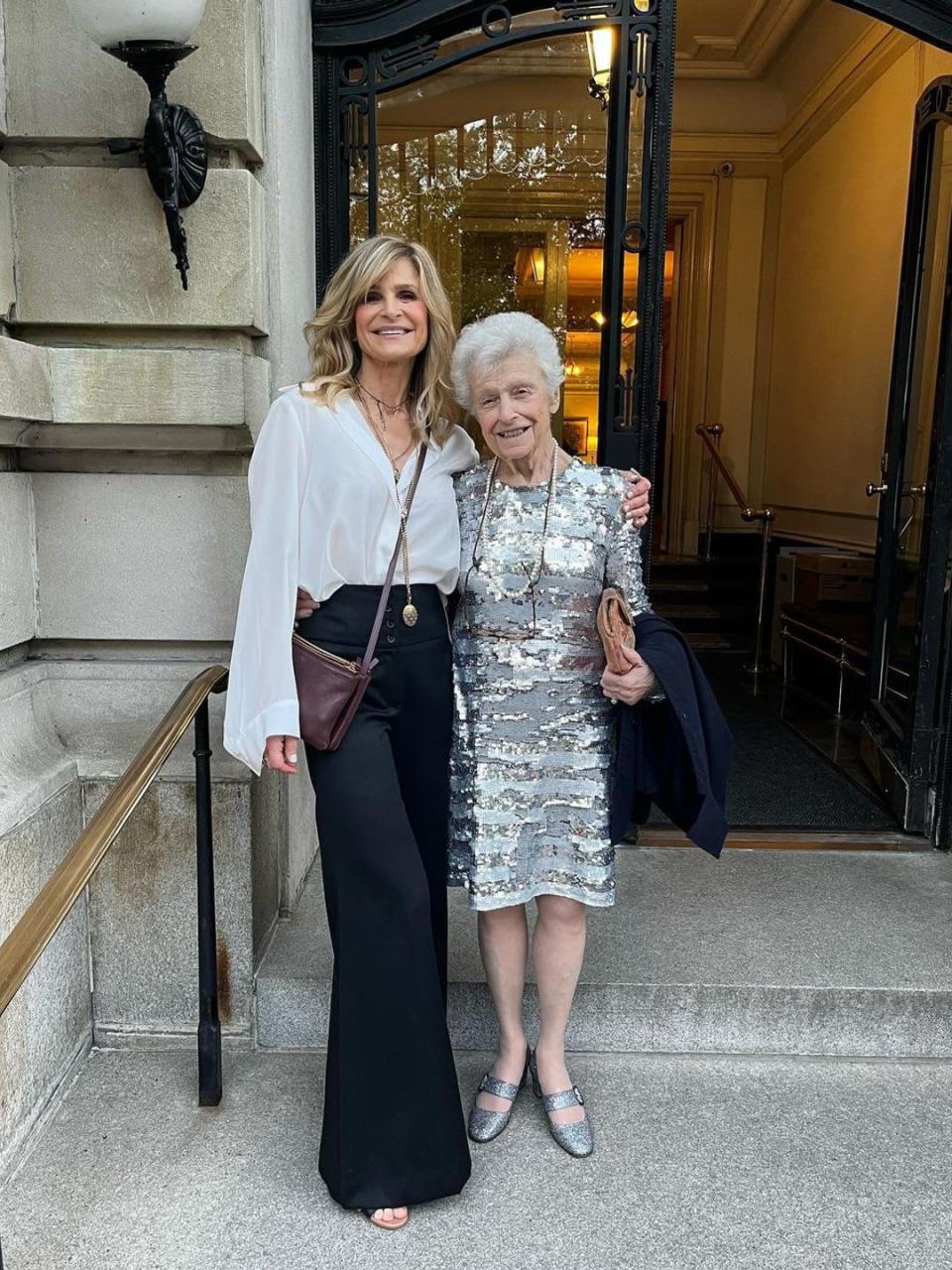 Kyra and Patricia poses for a photo all dressed up on the stairs to a fancy building