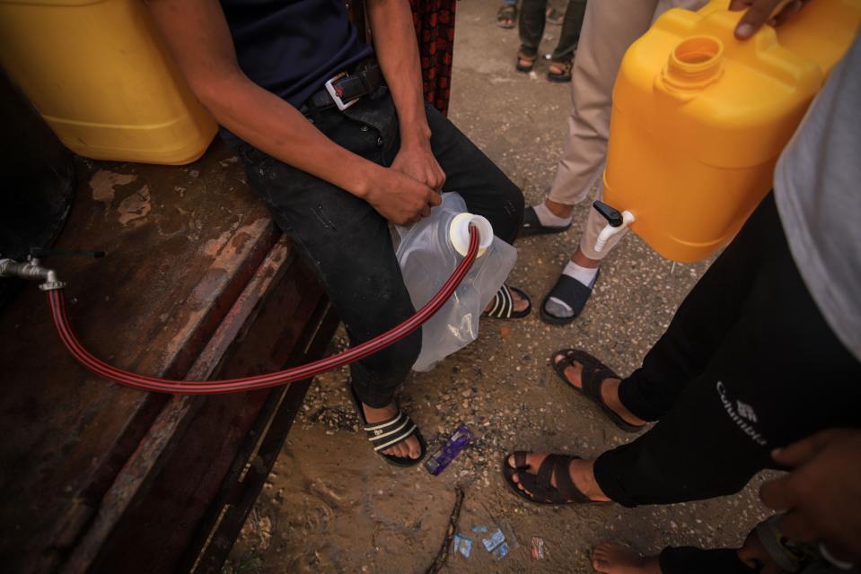 A Palestinian boy fills containers with water from a mobile tank in western Khan Younis, Gaza, on Oct. 31. (Photo: Ahmad Salem/Bloomberg)