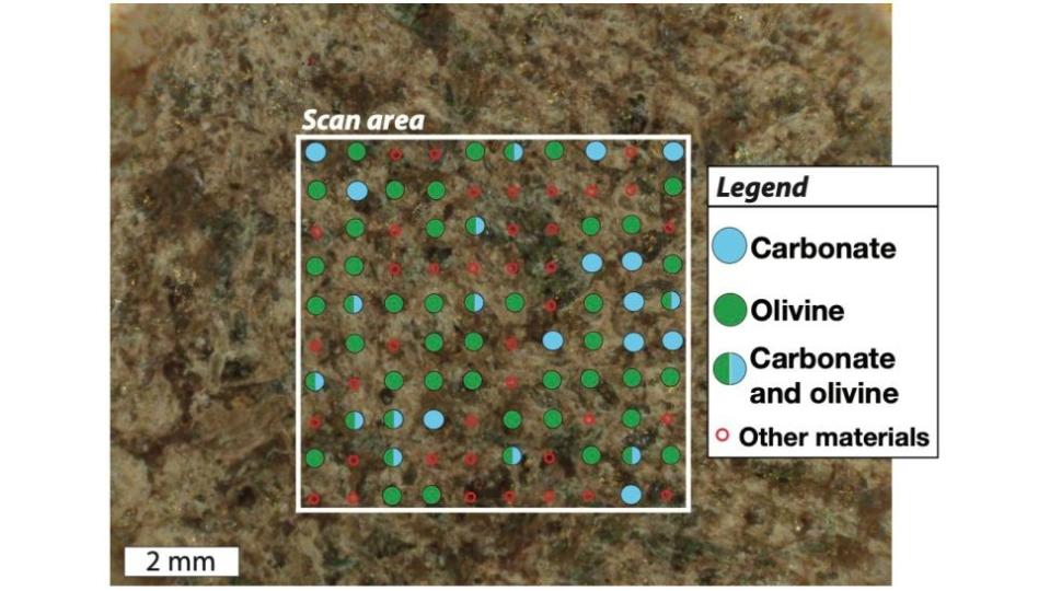 Close-up image of a mars rock with green and blue dots superimposed over it to represent chemical composition in different areas.