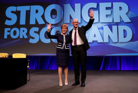 Nicola Sturgeon, First Minister of Scotland, and Deputy First Minister John Swinney wave at the Scottish National Party (SNP)'s party conference in Aberdeen, Scotland, Britain March 17, 2017. REUTERS/Russell Cheyne