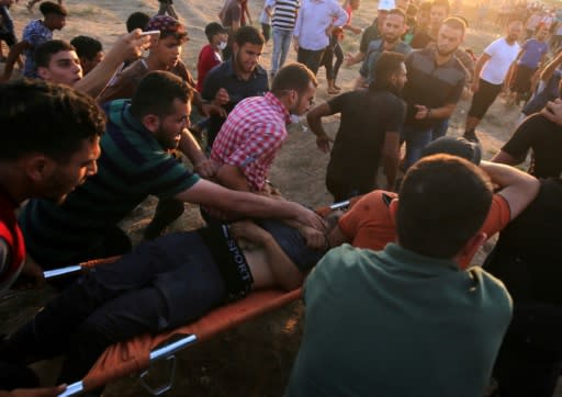 Palestinian paramedics carry an protester injured during a demonstration along the Israeli fence east of Gaza City on September 14, 2018