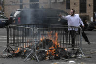 A man tosses bread into a fire as part of a Jewish ritual of cleansing a home of leavened bread, Wednesday, April 8, 2020 on the first day of Passover in the Williamsburg neighborhood of New York during the coronavirus pandemic. (AP Photo/Mark Lennihan)