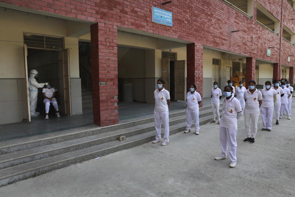 Members of Delhi civil defense wait to get themselves tested for COVID-19 before being deployed to various testing centers in New Delhi, India, Saturday, Oct. 3, 2020. India has crossed 100,000 confirmed COVID-19 deaths on Saturday, putting the country's toll at nearly 10% of the global fatalities and behind only the United States and Brazil. (AP Photo/Manish Swarup)