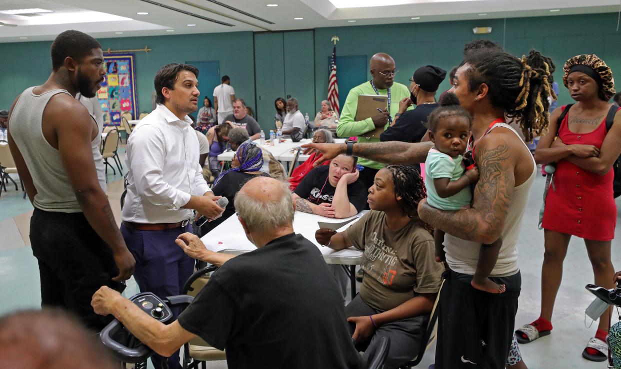 Mayor Shammas Malik, center, listens to the medical concerns of Terrell Anderson, left, and Jordan Snow, right, after informing residents that they may not be able to return home tonight as crews continue to battle a fire at an evacuation center set up inside Firestone Park Community Center, Thursday, Sept. 5, 2024, in Akron, Ohio. Jeff Lange, Akron Beacon Journal