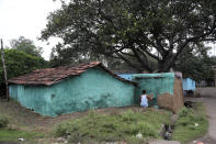 In this Oct. 23, 2019, photo, a villager paints his house in preparation of Diwali, a Hindu festival, in the village of Bastakola involved in coal mining in Jharia, a remote corner of eastern Jharkhand state, India. Coal is an important contributor to India’s growth, supporting its iron and steel industry and generating more than half the country’s power. In Jharia, the heart of India’s coal industry, the livelihoods of half a million people depend on it. (AP Photo/Aijaz Rahi)