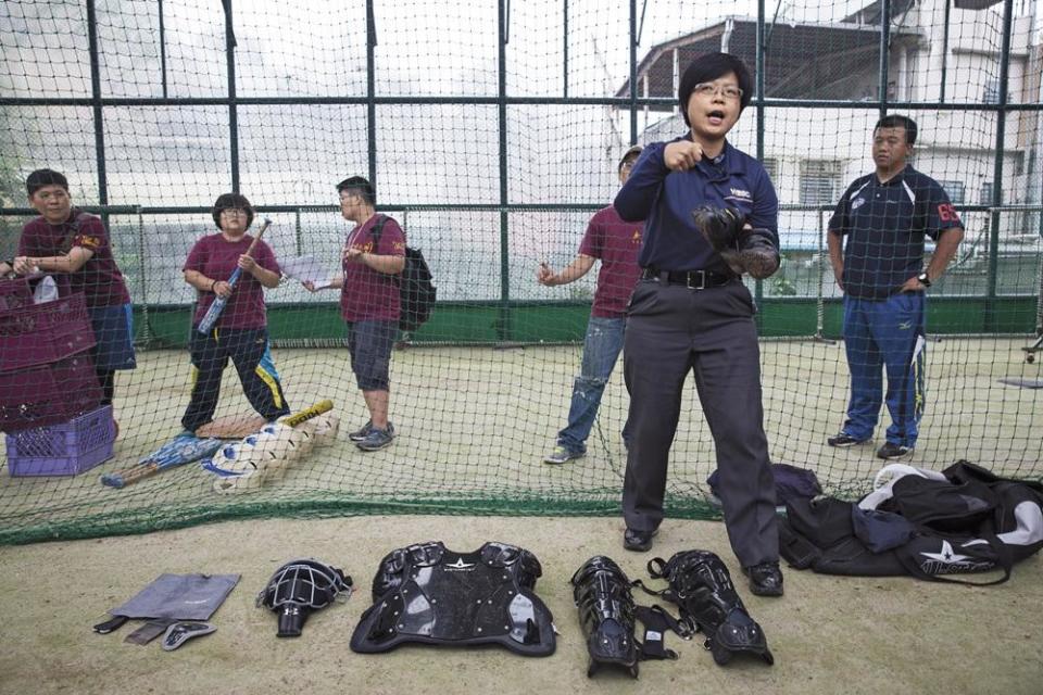 劉柏君（前）是台灣第一位棒球女主審，這天她教大家認識裁判護具，推廣年輕女性打棒球。