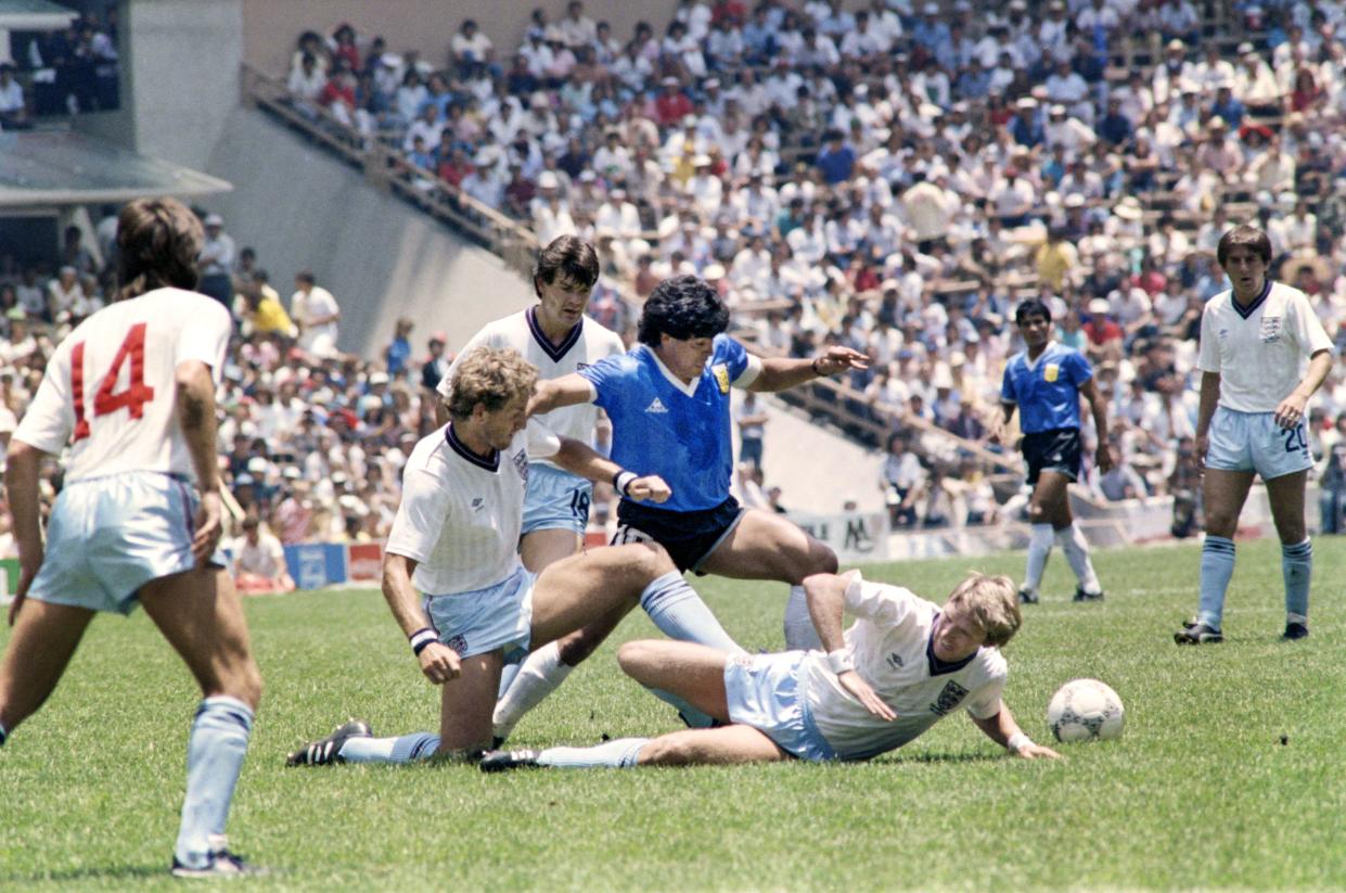 Argentinian midfielder Diego Maradona (C) dribbles past three English defenders on June 22, 1986 in Mexico City during the World Cup quarterfinal soccer match between Argentina and England. Maradona scored two goals, the first one with his left hand as he jumped for the ball in front of goalkeeper Peter Shilton, as Argentina beat England 2-1. (Photo by STAFF / AFP)        (Photo credit should read STAFF/AFP via Getty Images)