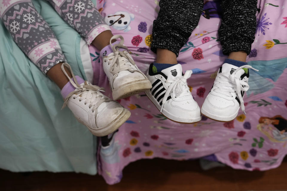 Alexa Llanos, 7, left, and little brother Alexis, 3, sit together on a bed in the home the family moved into in October 2023, five years after fleeing Venezuela to Colombia to escape death threats and political persecution, in Lehigh Acres, Fla., Dec. 27, 2023. The family is among the first migrants allowed into the U.S. under the Biden administration's new "safe mobility offices," intended to streamline the U.S. refugee process so migrants don't give up and pay smugglers to make the journey north. (AP Photo/Rebecca Blackwell)