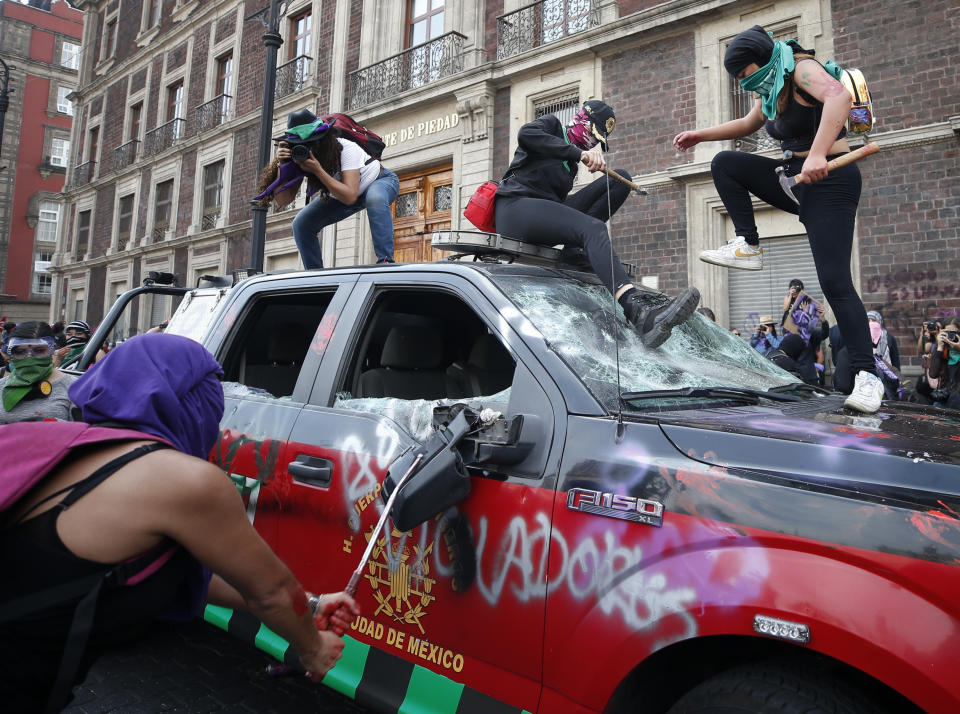 Demonstrators attack a fire department truck to protest gender violence during a march marking International Women's Day in Mexico City's main square, the Zocalo, Sunday, March 8, 2020. (AP Photo/Rebecca Blackwell)