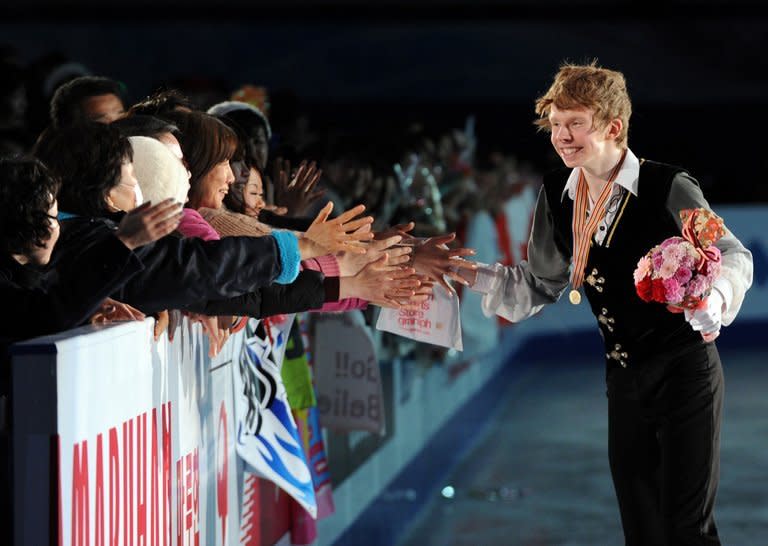 Four Continents figure skating championships men's event winner Canada's Kevin Reynolds is congratulated by spectators during the awards ceremony in Osaka on February 9, 2013. Reynolds took the men's title at the championships in his first major international victory