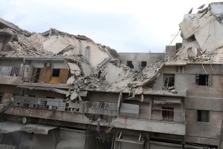 People inspect a damaged site after airstrikes on the rebel held al-Qaterji neighborhood of Aleppo, Syria. REUTERS/Abdalrhman Ismail