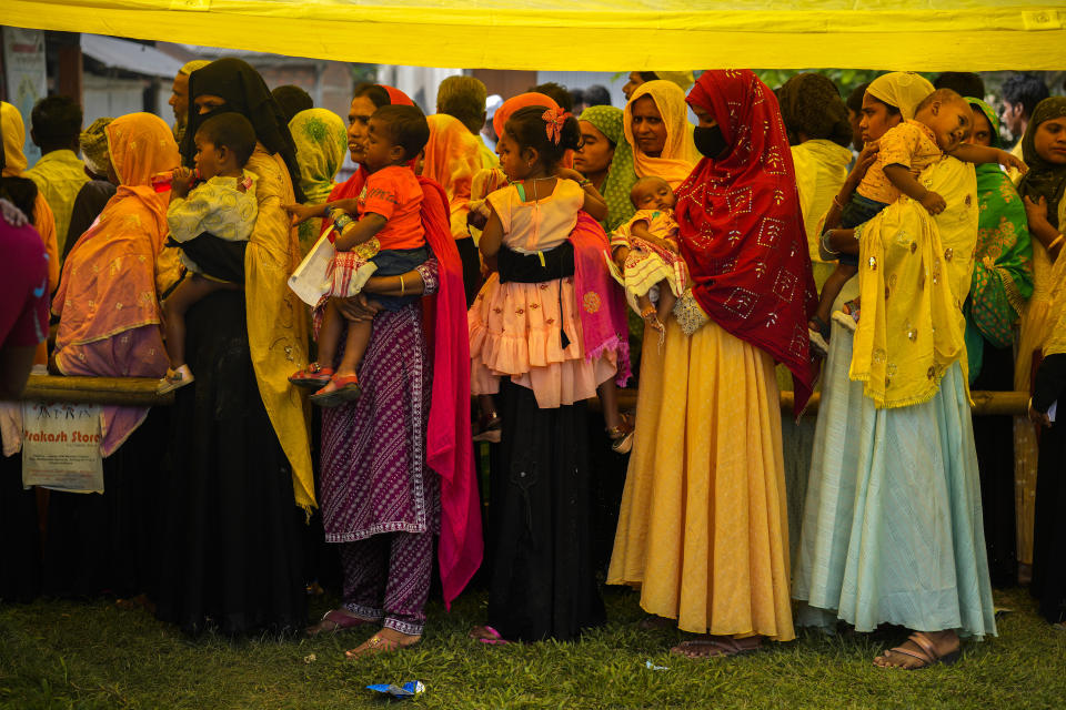 Women hold their babies as they queue up to cast their votes in a polling station on the bank of the Brahmaputra river during the second round of voting in the six-week-long national election in Morigaon district, Assam, India, Friday, April 26, 2024. (AP Photo/Anupam Nath)