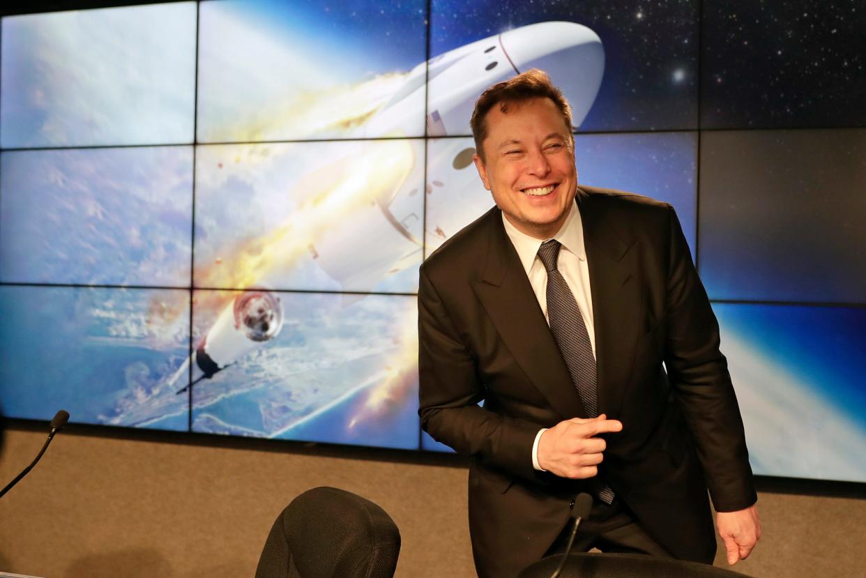 Elon Musk in front of image of SpaceX rocket.